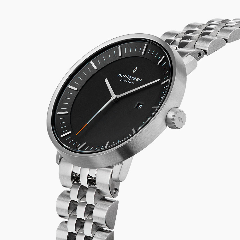 Angled view of the brushed silver-tone case, crown and black dial with date.