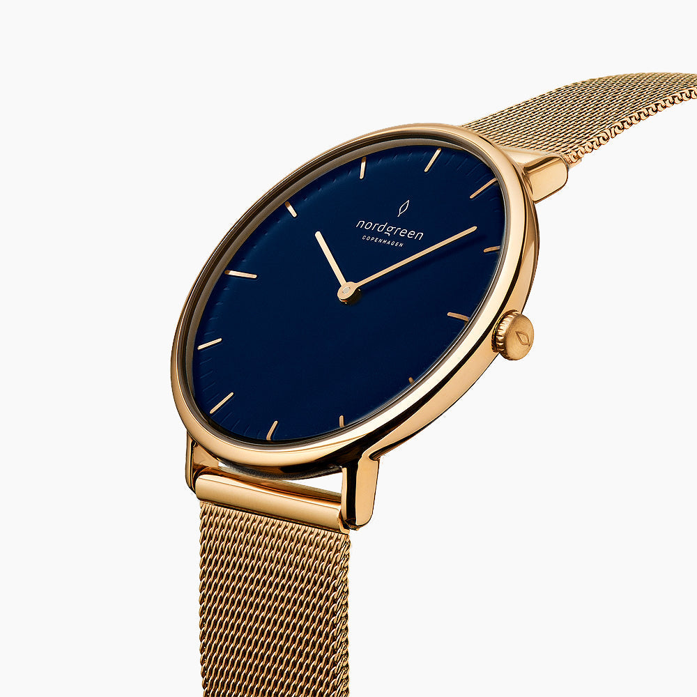 Three-quarter view of the watch showing the blue sunburst dial and gold-tone mesh strap.