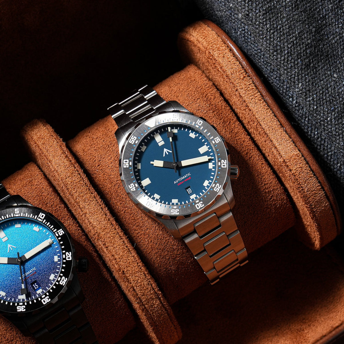 Blue-dial sports watch displayed in a brown watch box