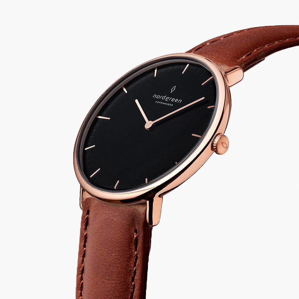 Watch turned at an angle, black dial and rose gold-tone bezel catching the light.