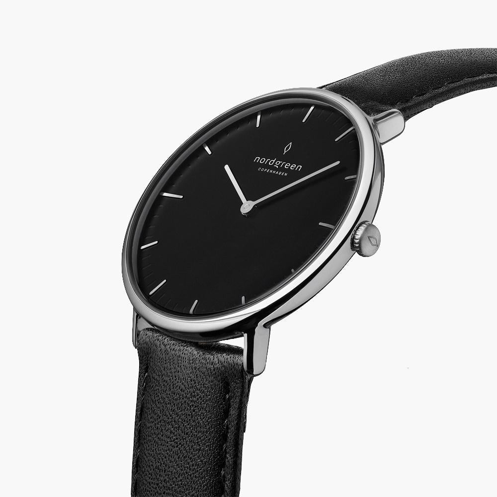 The silver-tone watch tilted to reveal its black dial and side crown.