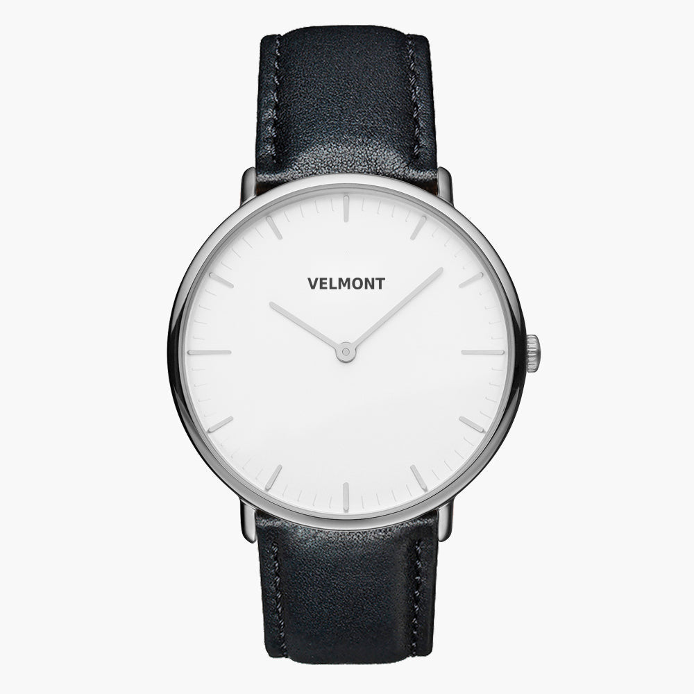 Minimal watch with a white dial and silver-tone case on a black strap, front view.