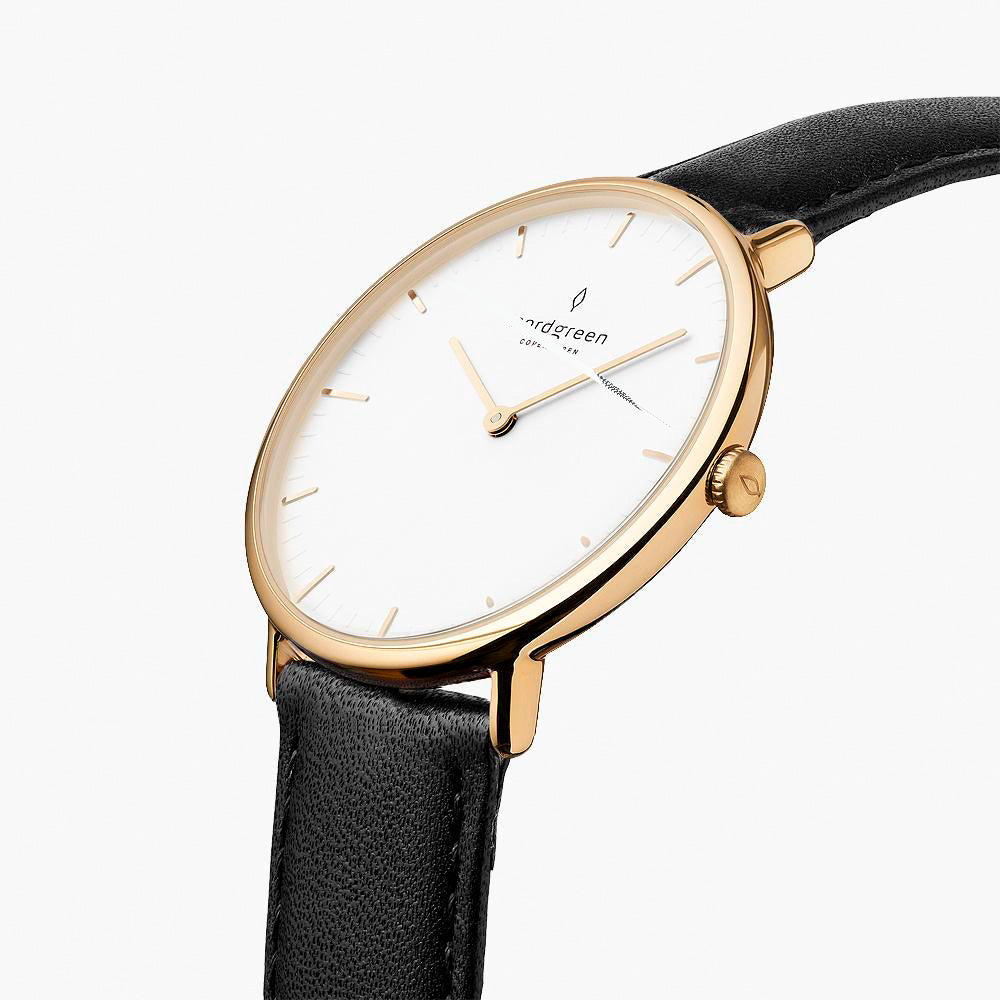 Angled view of the slim gold-tone case and crown on a black strap.