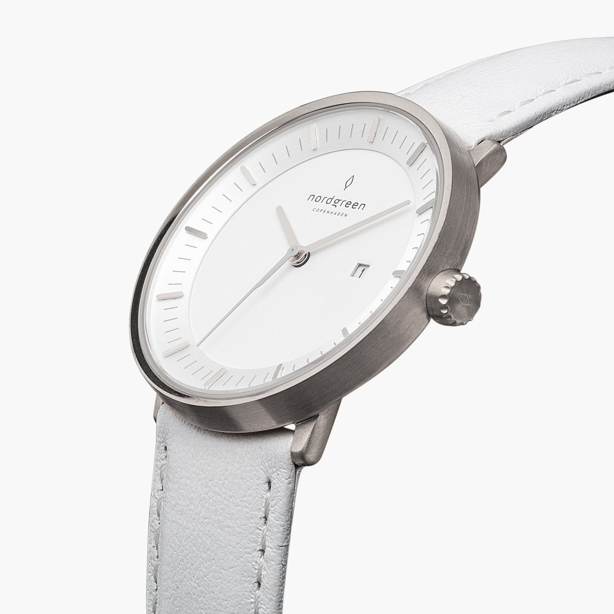 Three-quarter view of the silver-tone case and date window on a white strap.