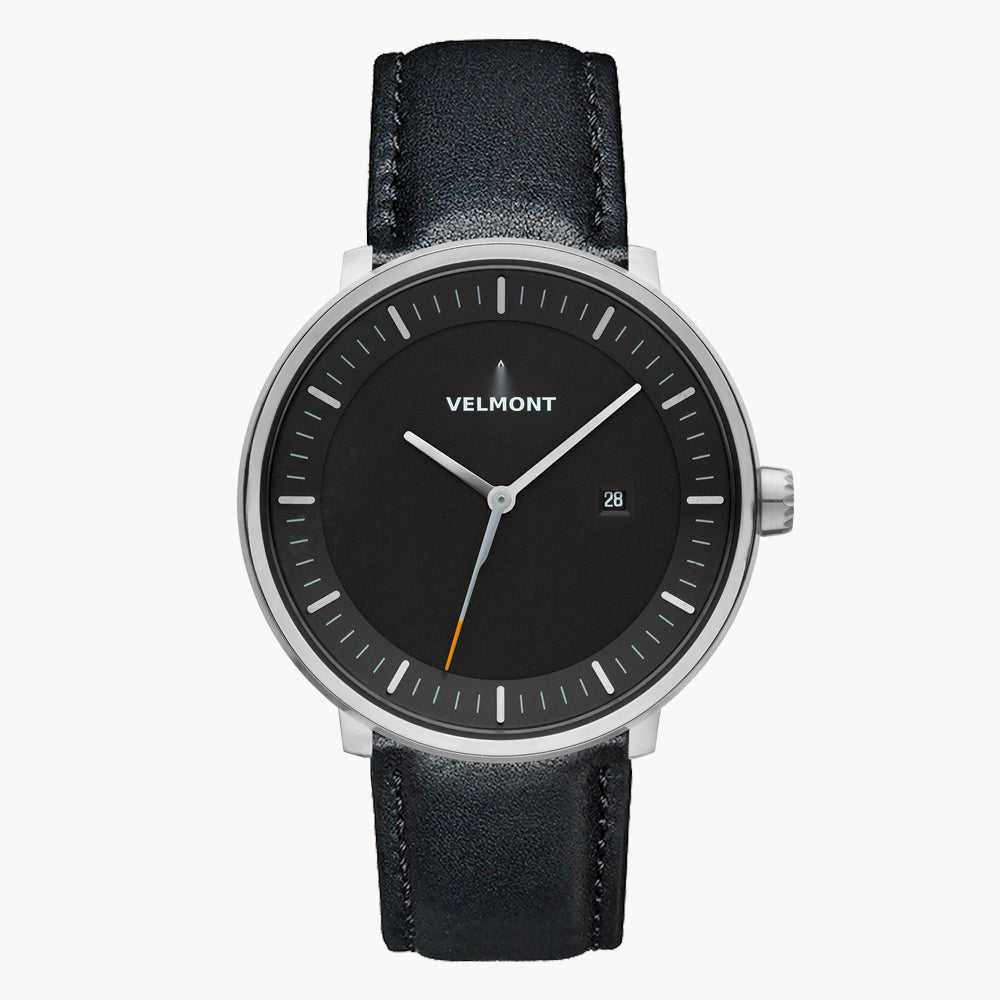 Watch with a black dial and silver-tone case on a black strap, shown from the front.