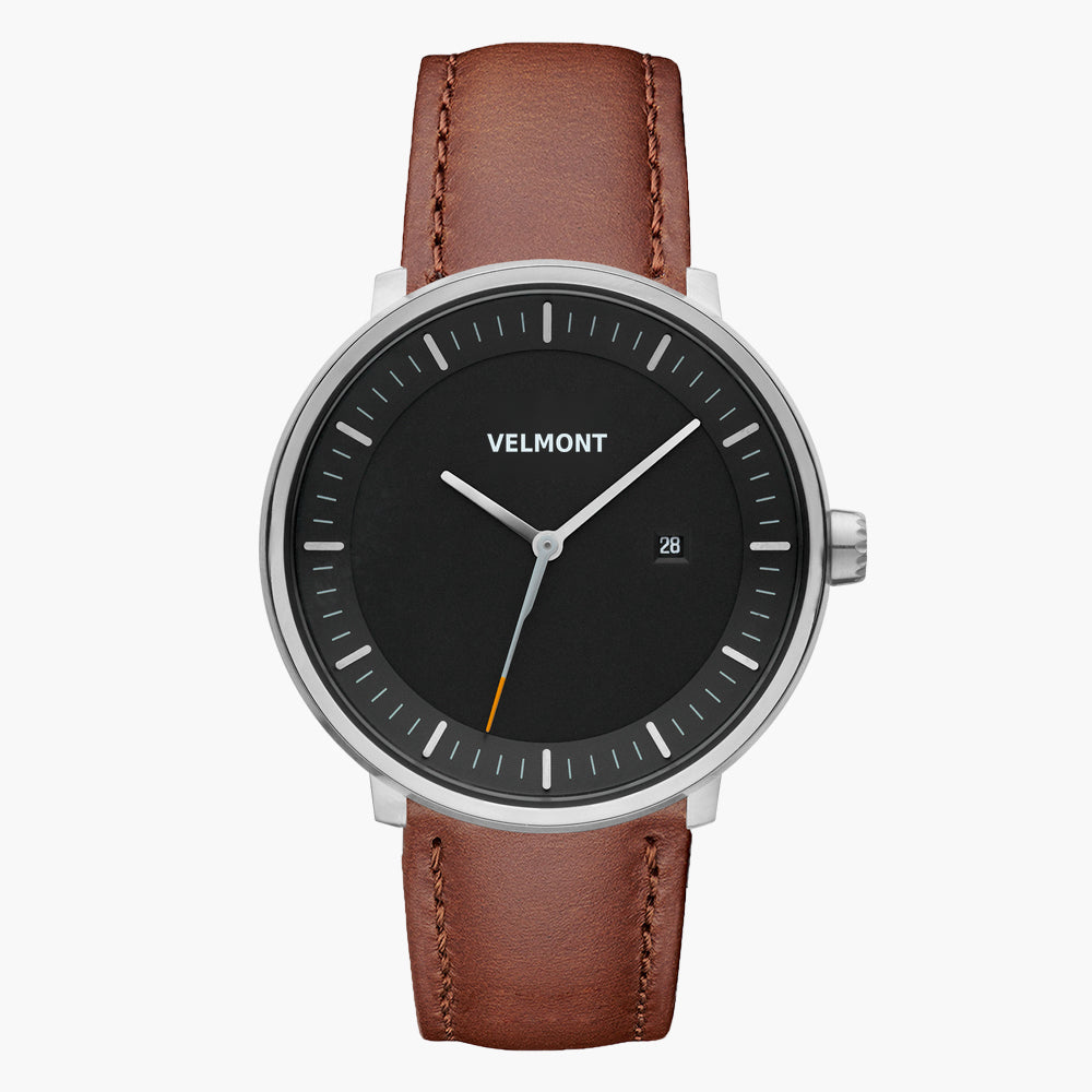 Watch with a black dial and silver-tone case on a brown strap, shown from the front.
