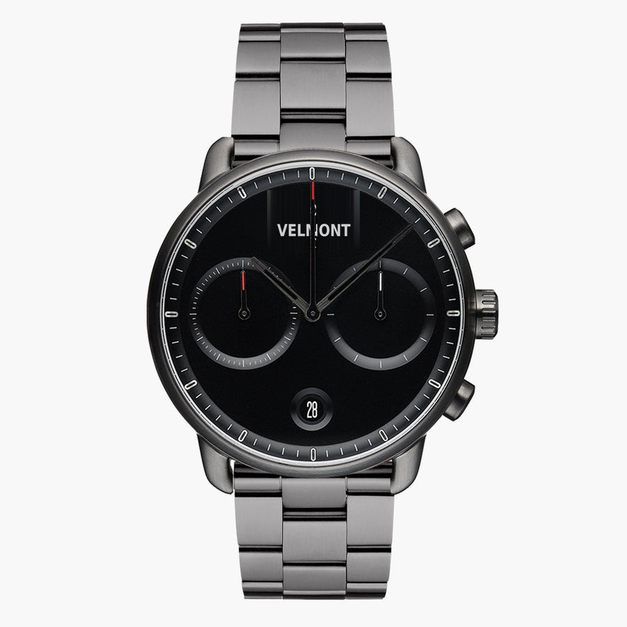 Chronograph-style watch with a black dial on a gunmetal link bracelet, front view.