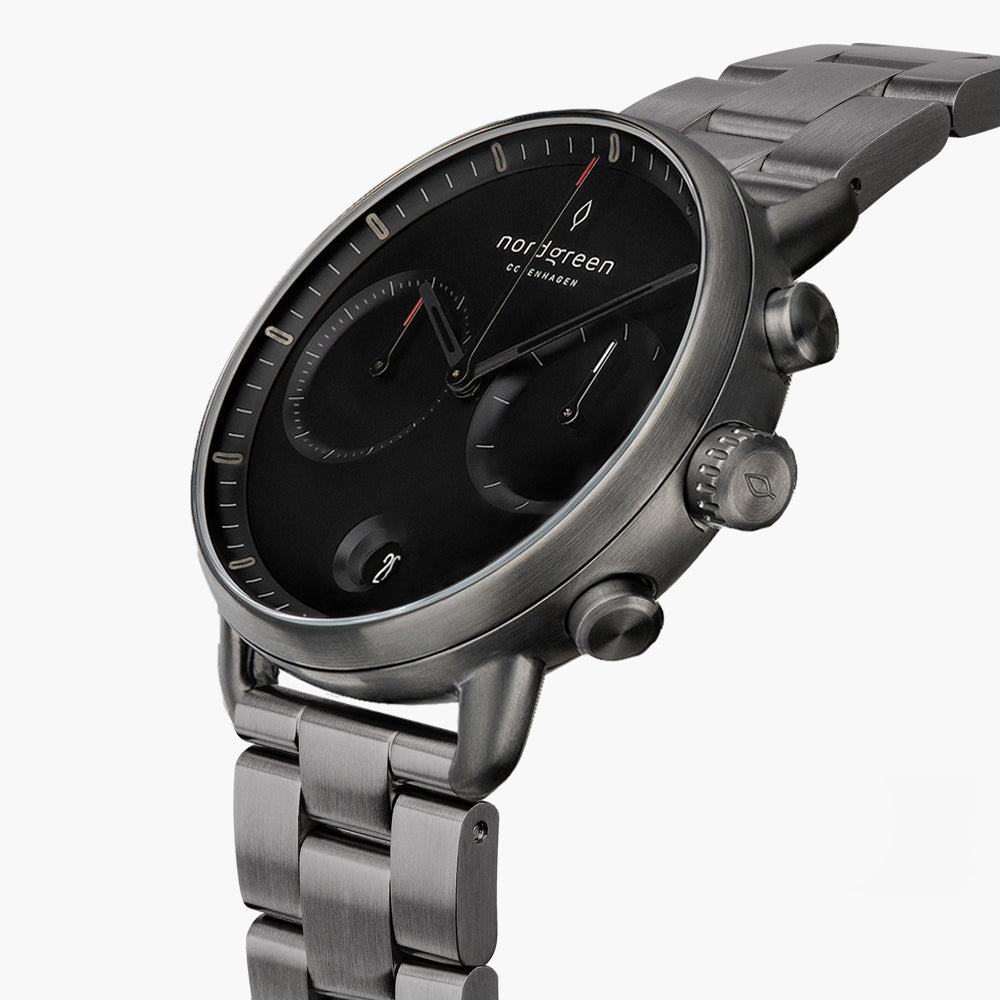 Angled view of the black dial, subdials and gunmetal pushers and bracelet.