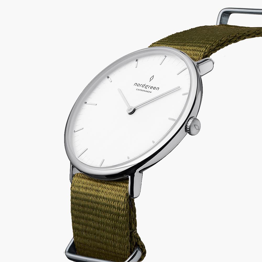 Three-quarter view of the watch showing the white dial and olive green woven strap.