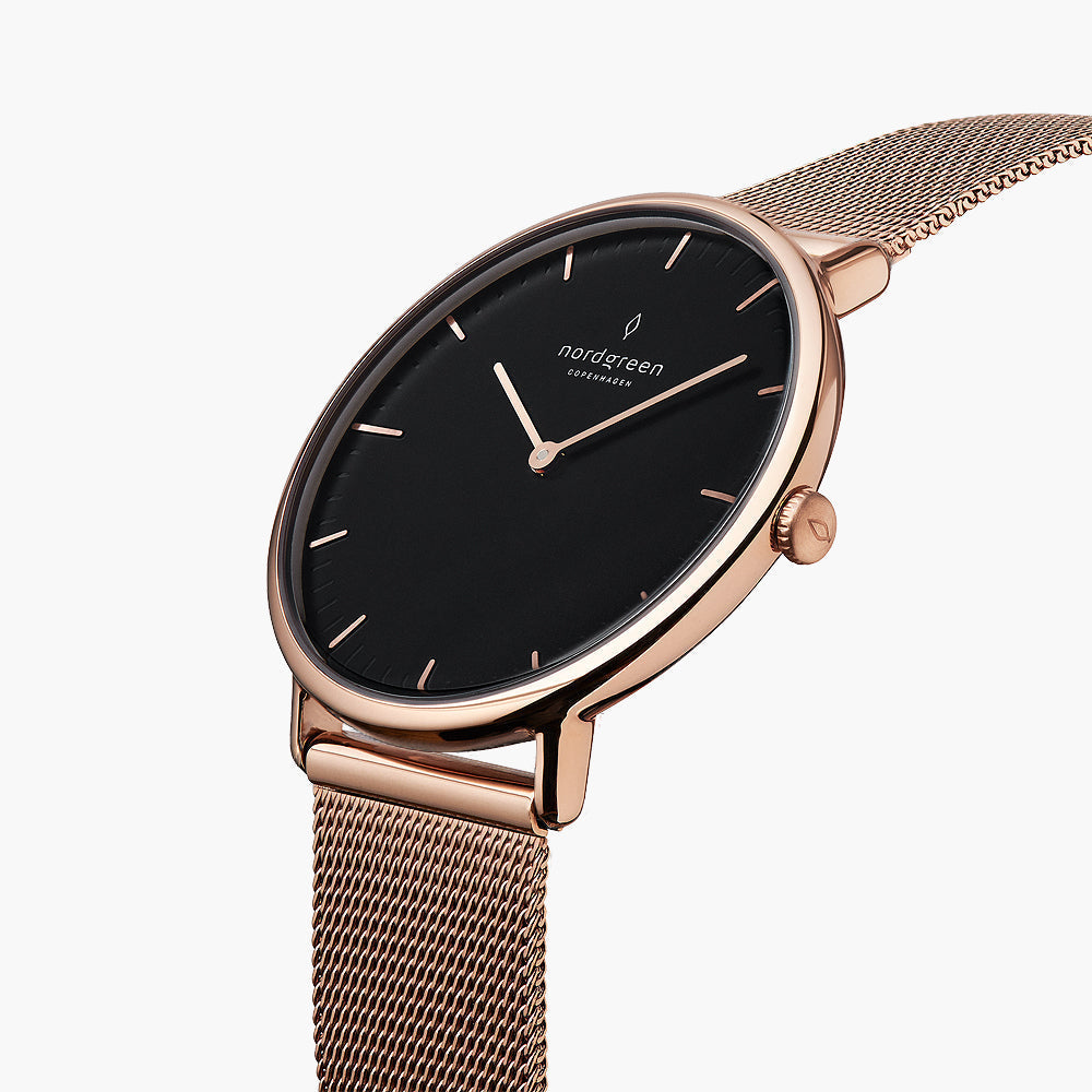 The rose gold-tone watch tilted to reveal its black dial and side crown.