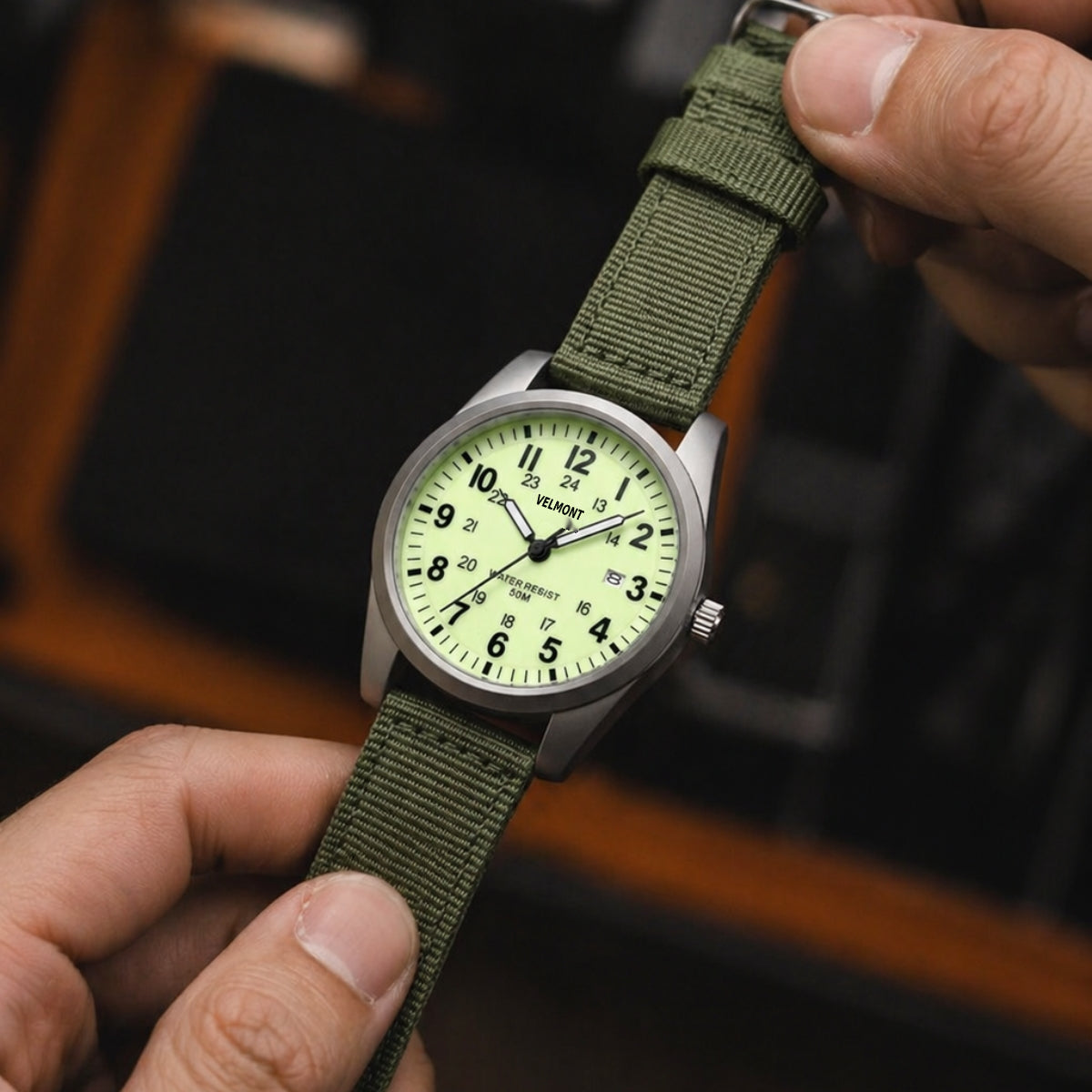 Field watch held between fingers
