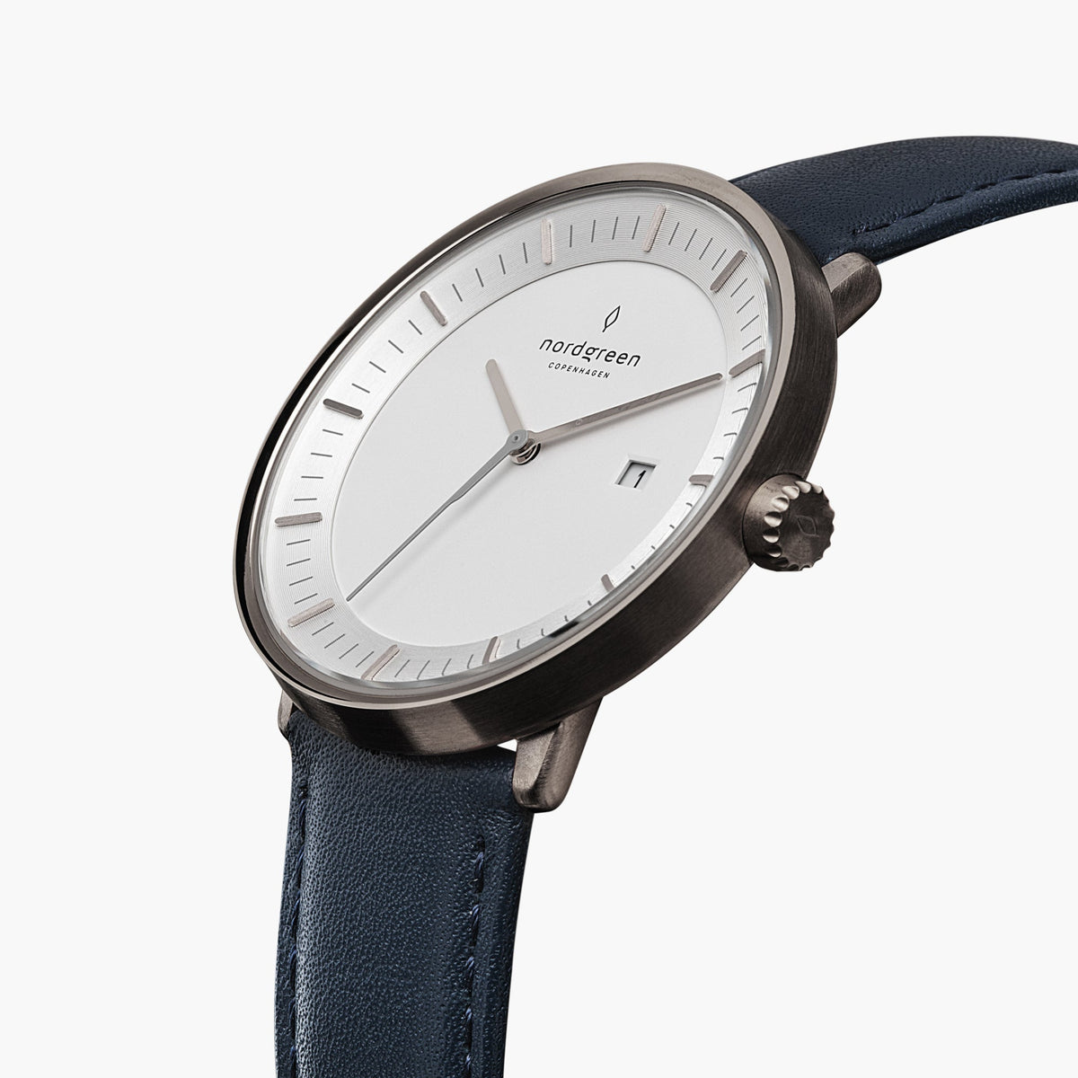 Three-quarter view of the white dial, date window and gunmetal crown on a navy strap.