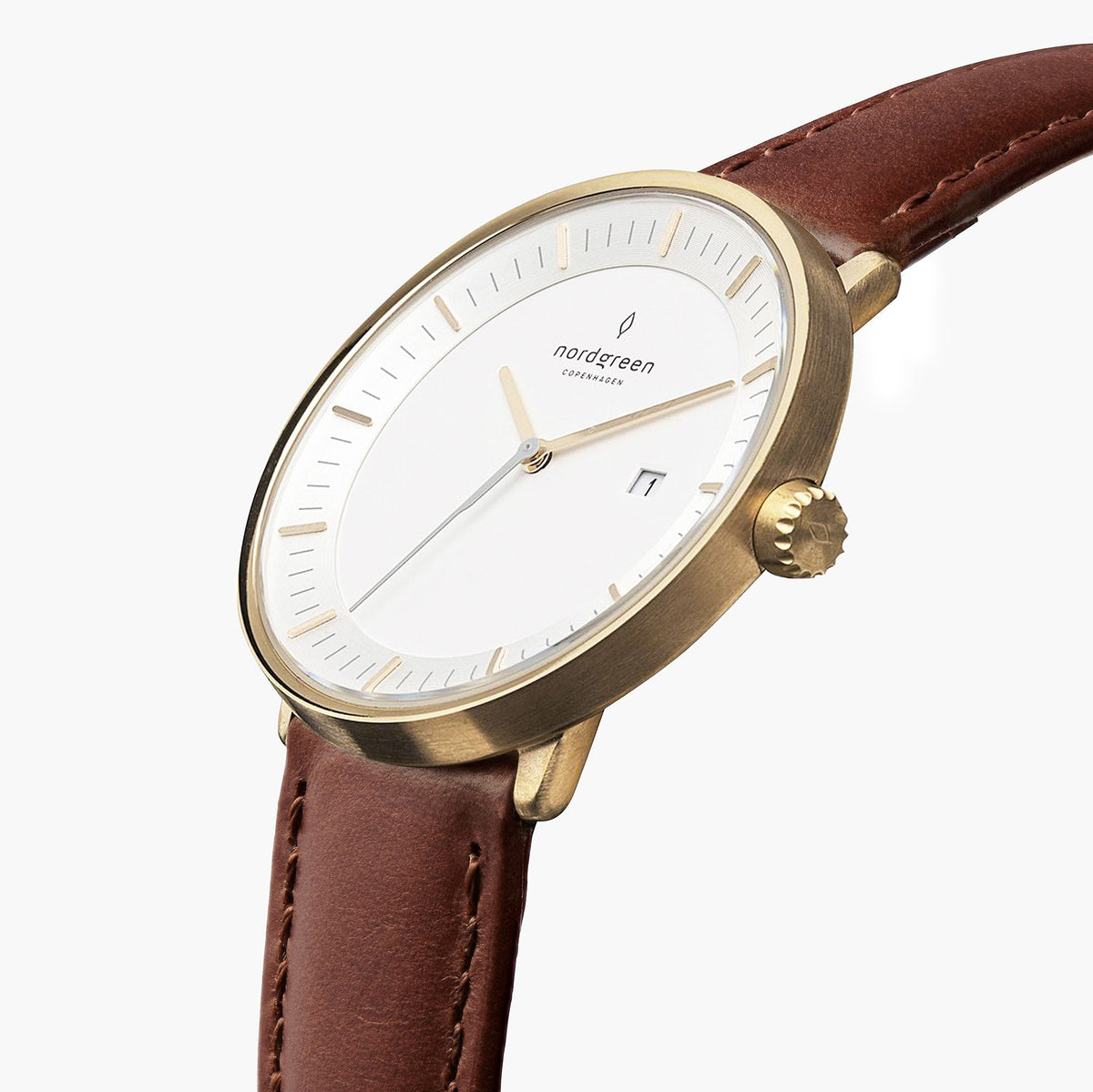 Watch turned at an angle, white dial and gold-tone bezel catching the light.
