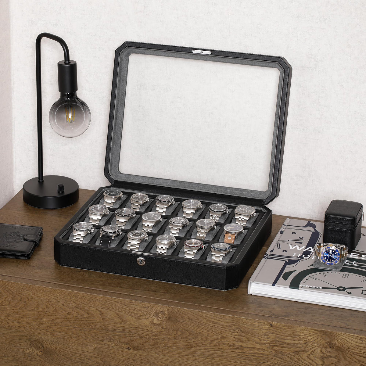Open eighteen-watch case with glass lid raised on a wooden desk