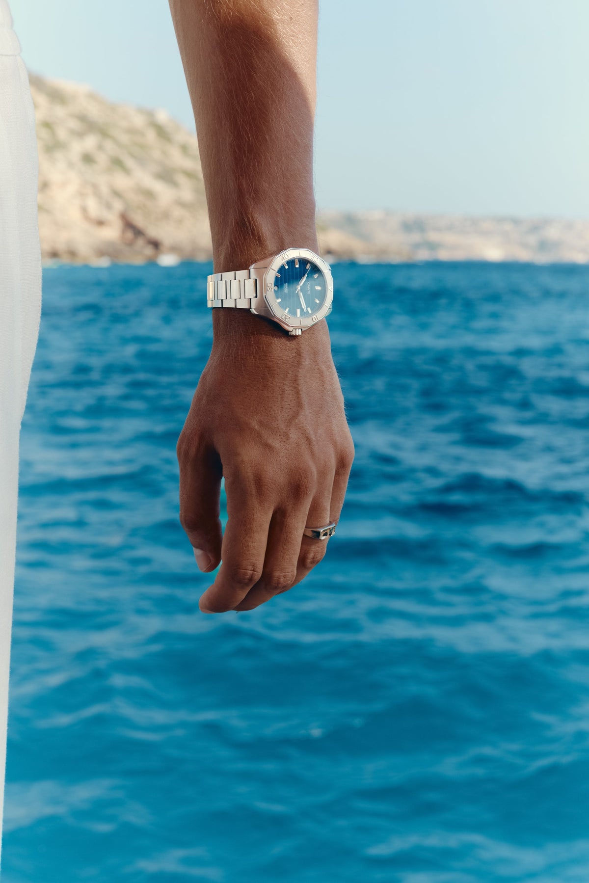 Close-up of the watch on the wrist, sea in the background
