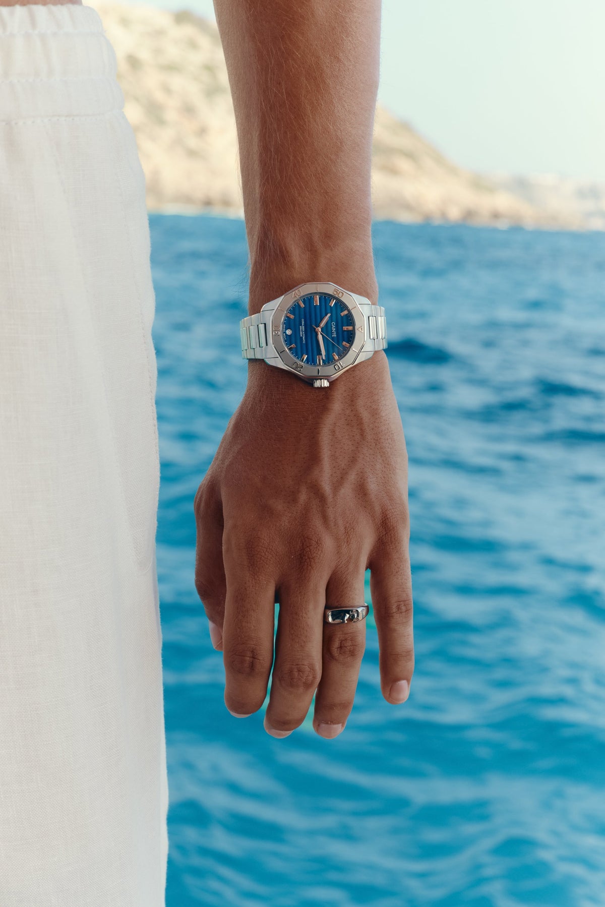 Close-up of the watch on the wrist, sea in the background