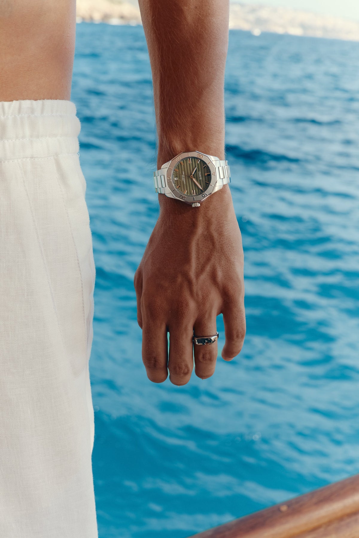 Green-dial automatic watch worn on the wrist by the sea