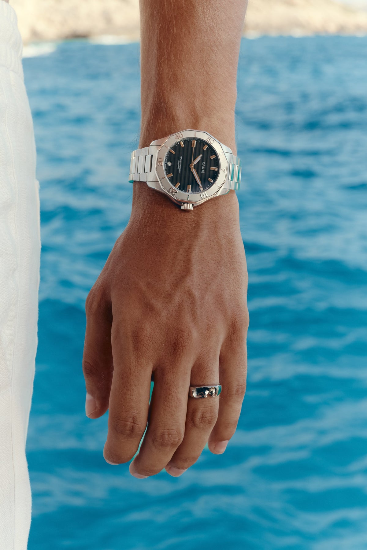 Close-up of the watch on the wrist, sea in the background