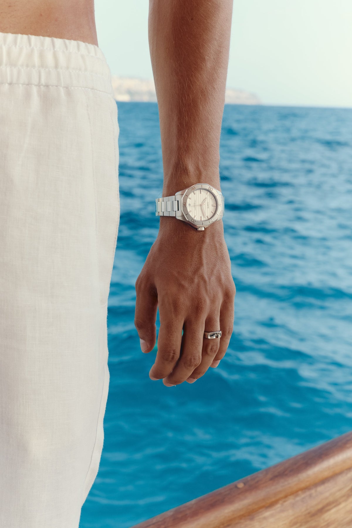 Close-up of the watch on the wrist, sea in the background