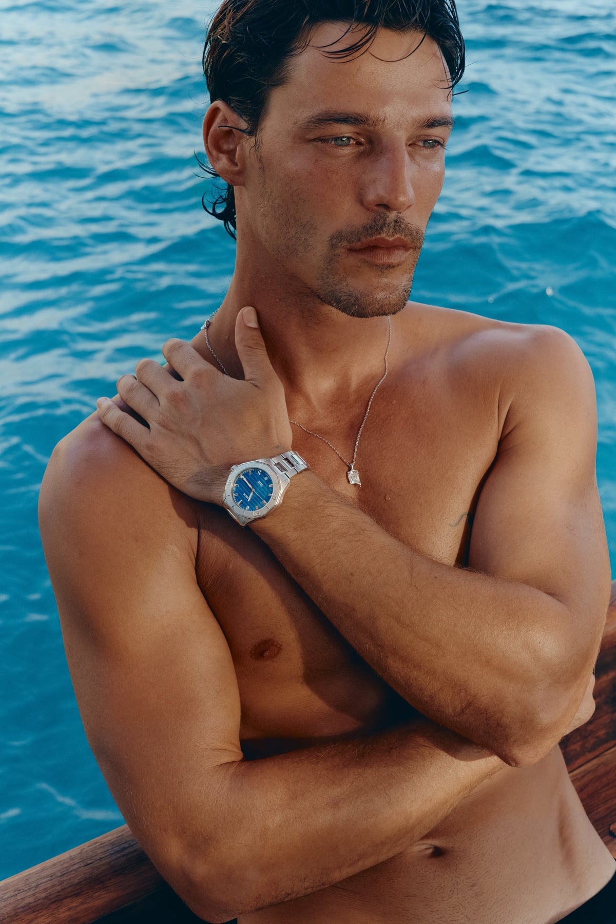 Arm across the chest showing the watch by the sea