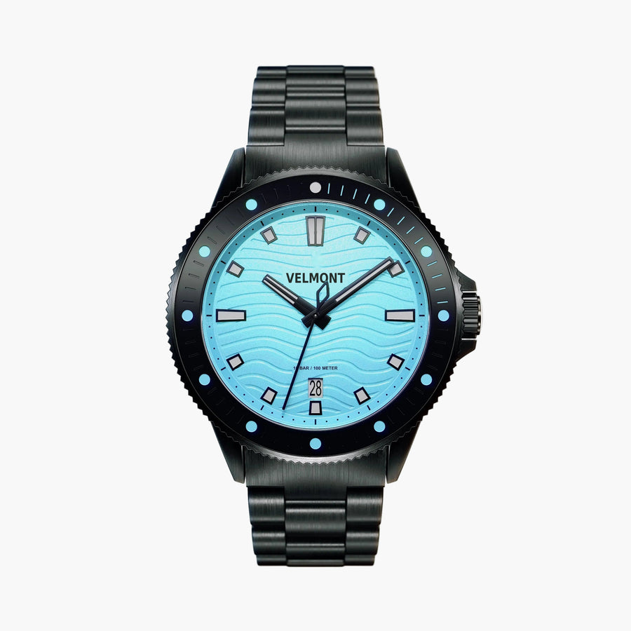 Diver-style watch with a light turquoise wave dial and black bezel on a black link bracelet.