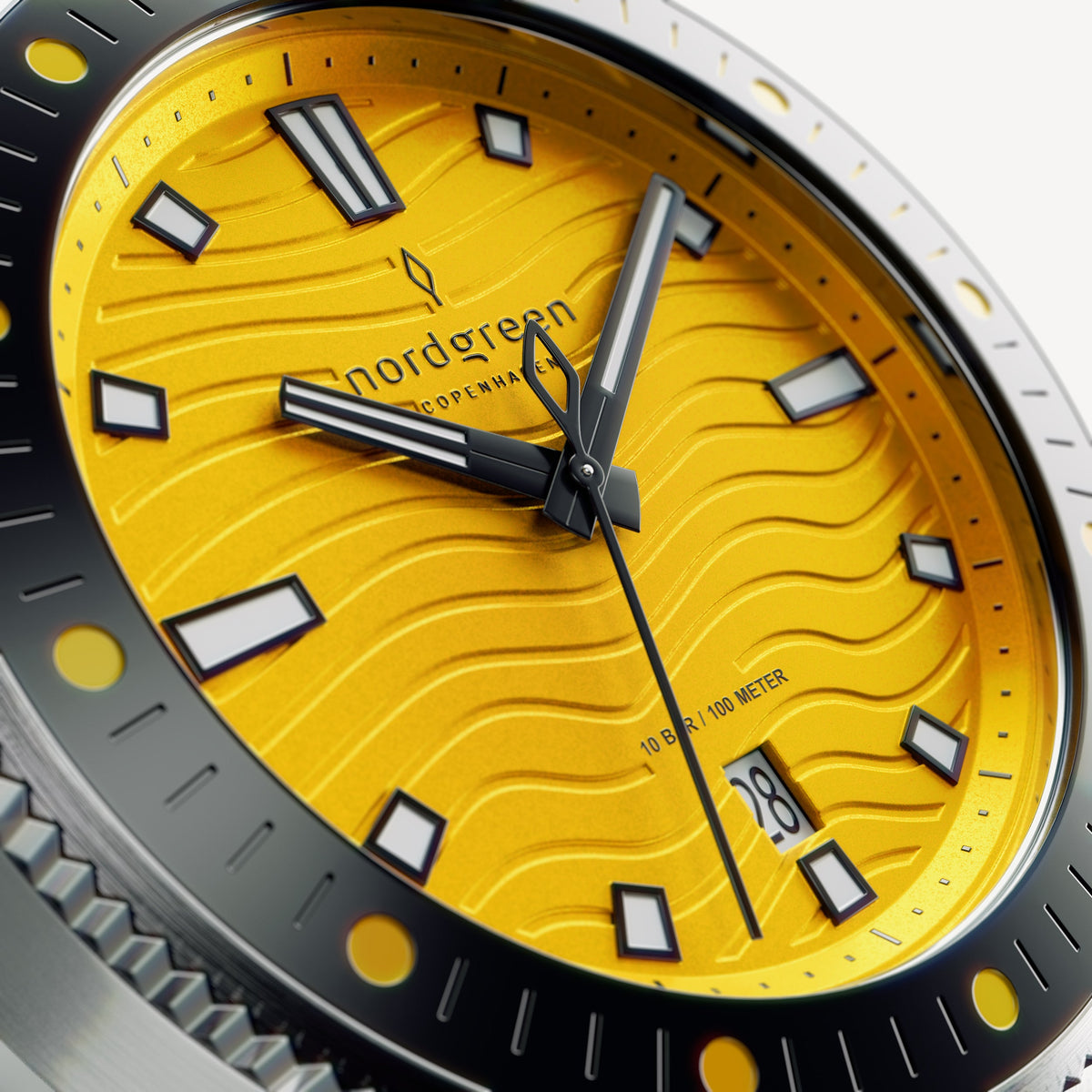 Close-up of the yellow wave-textured dial with outlined indices and dark hands.