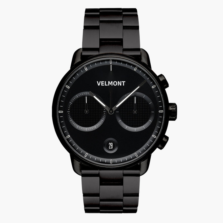 All-black chronograph-style watch with textured subdials on a black link bracelet.