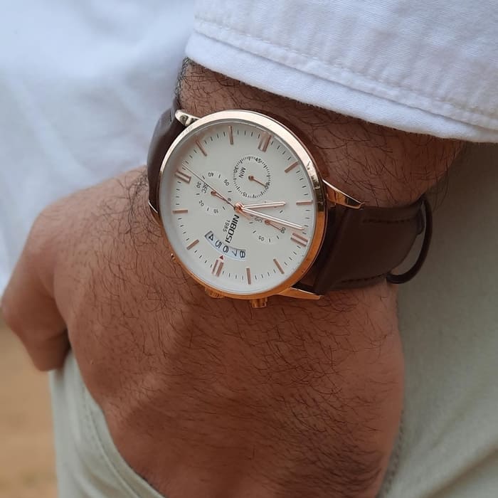 Rose gold-tone chronograph on a wrist in a white shirt