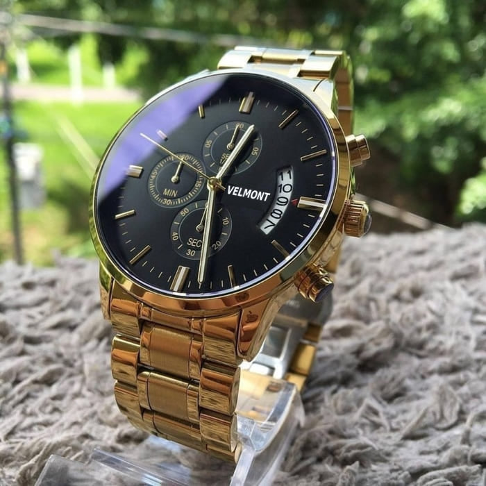 Gold-tone watch outdoors on a cushion