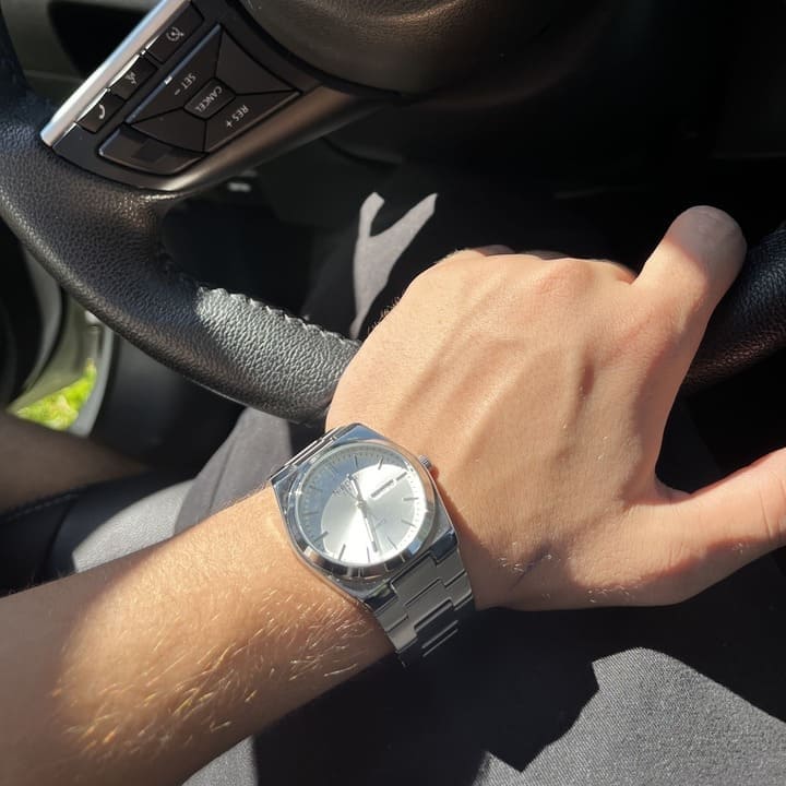 Silver watch on a wrist in a car