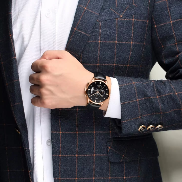 Black dial rose gold-tone chronograph worn with a suit