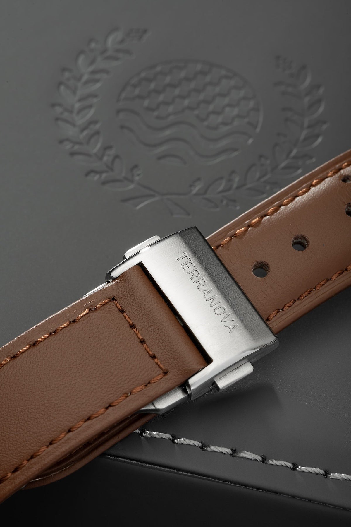 Brown strap and buckle on an embossed surface