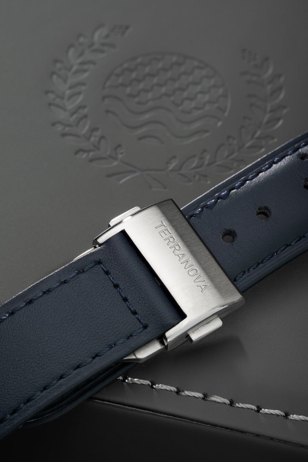 Blue strap and buckle on an embossed surface