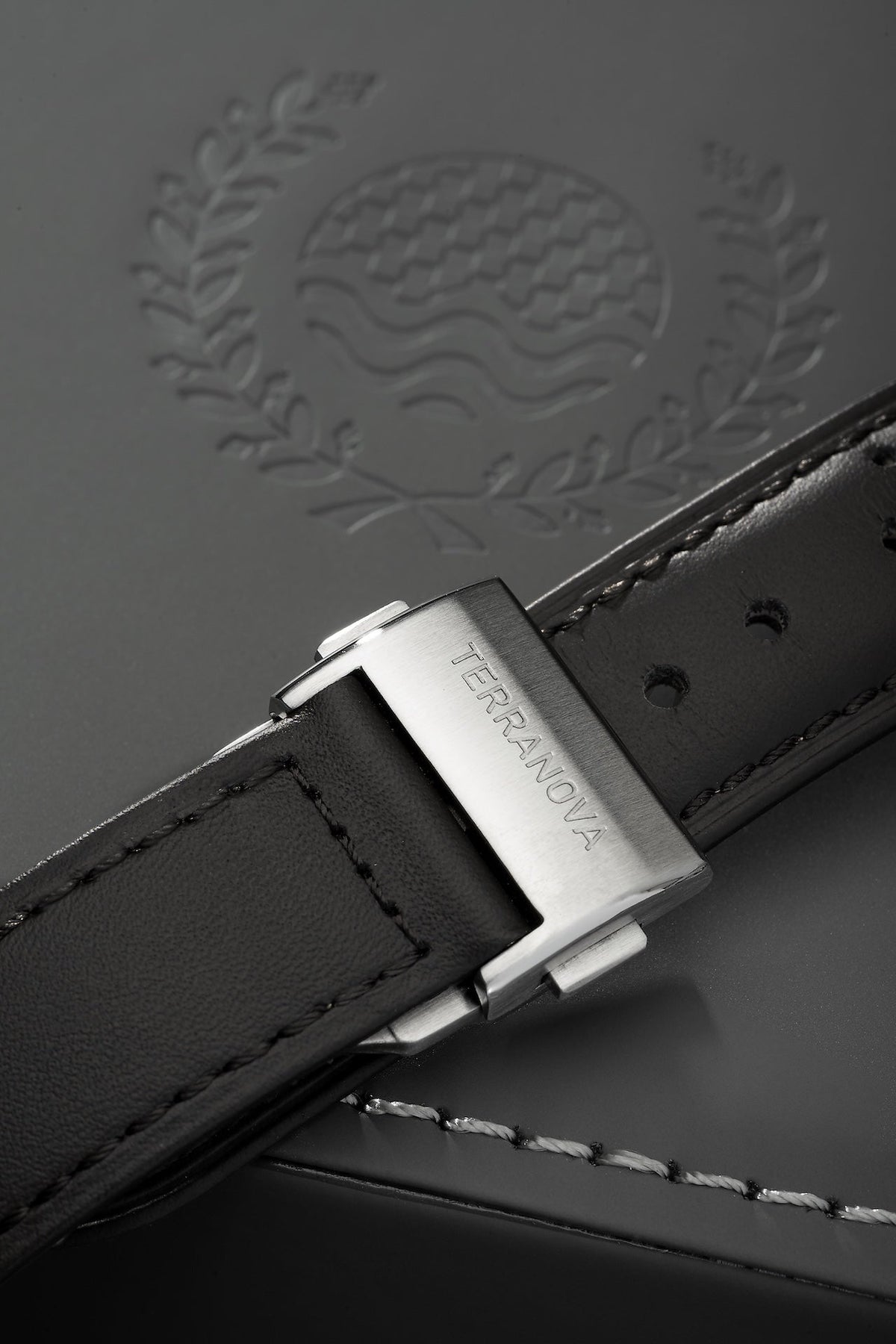 Black strap and buckle on an embossed surface
