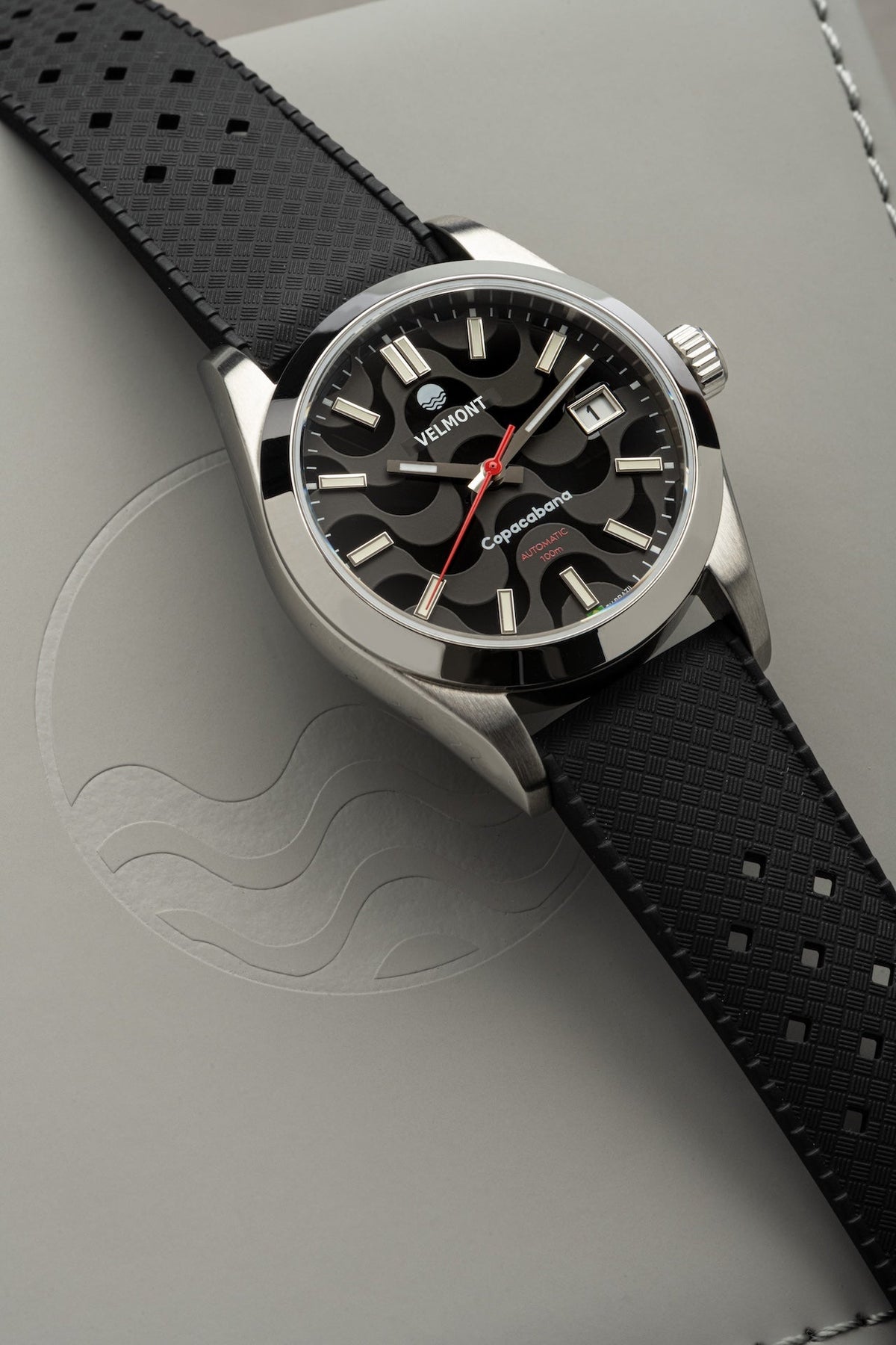 Black dial watch on black strap at an angle