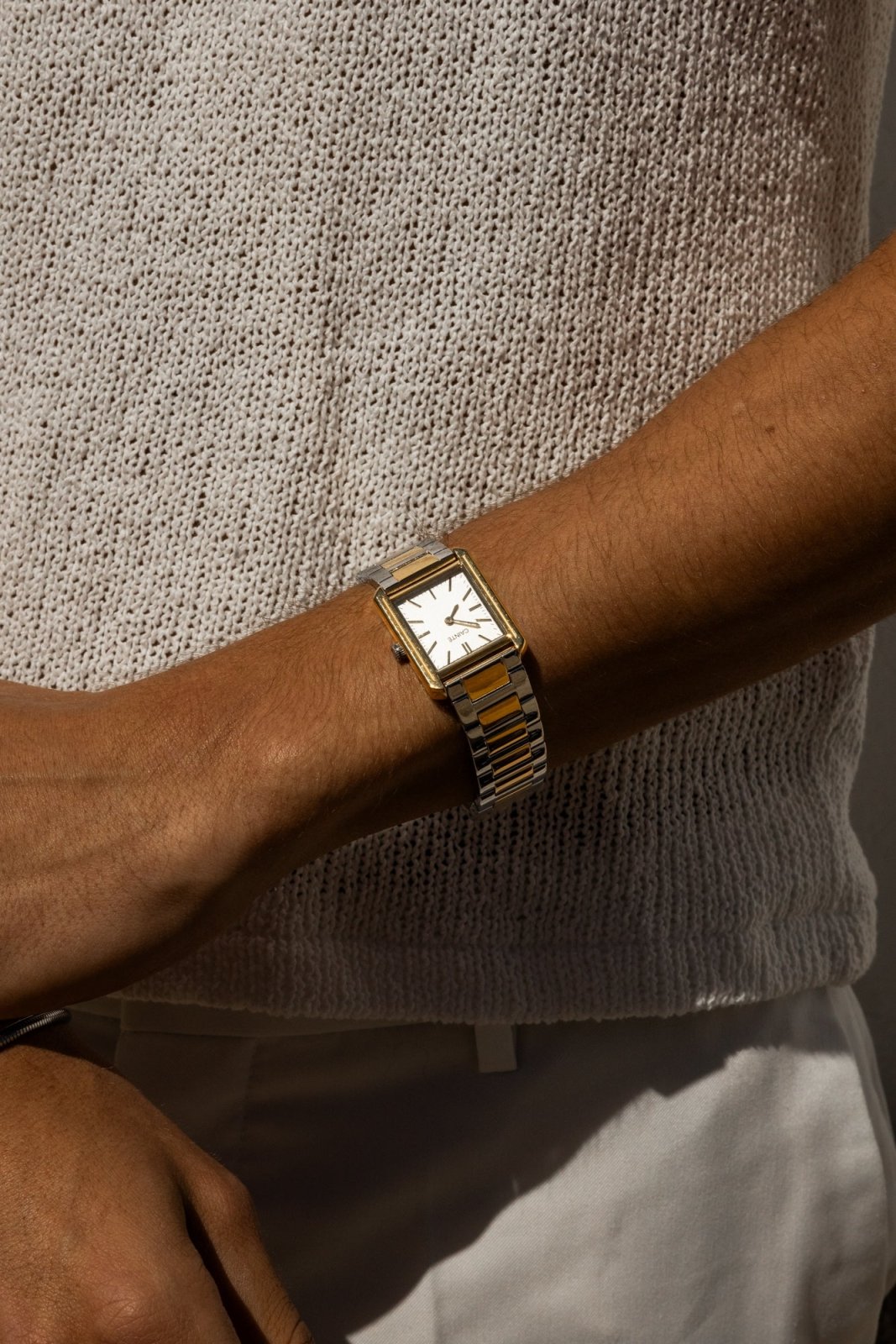 Wrist in a knit sweater wearing the rectangular watch