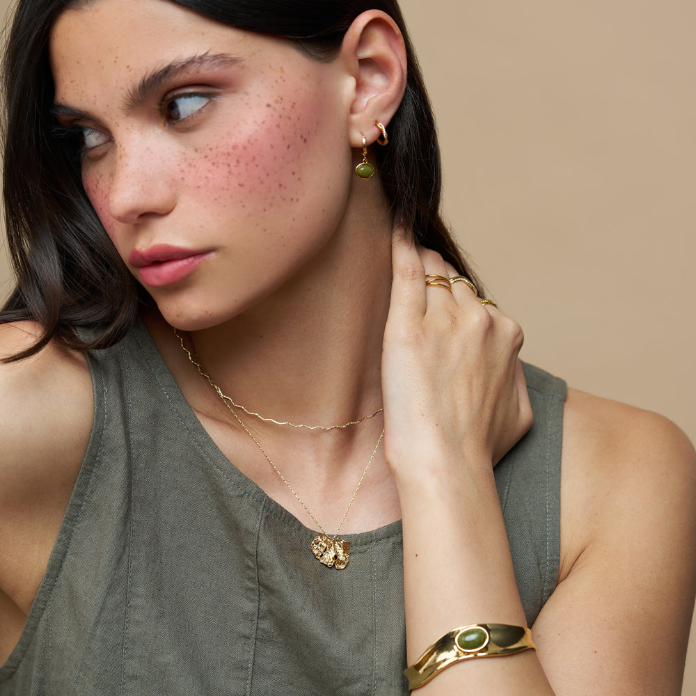 Model wearing the green stone cuff with a necklace