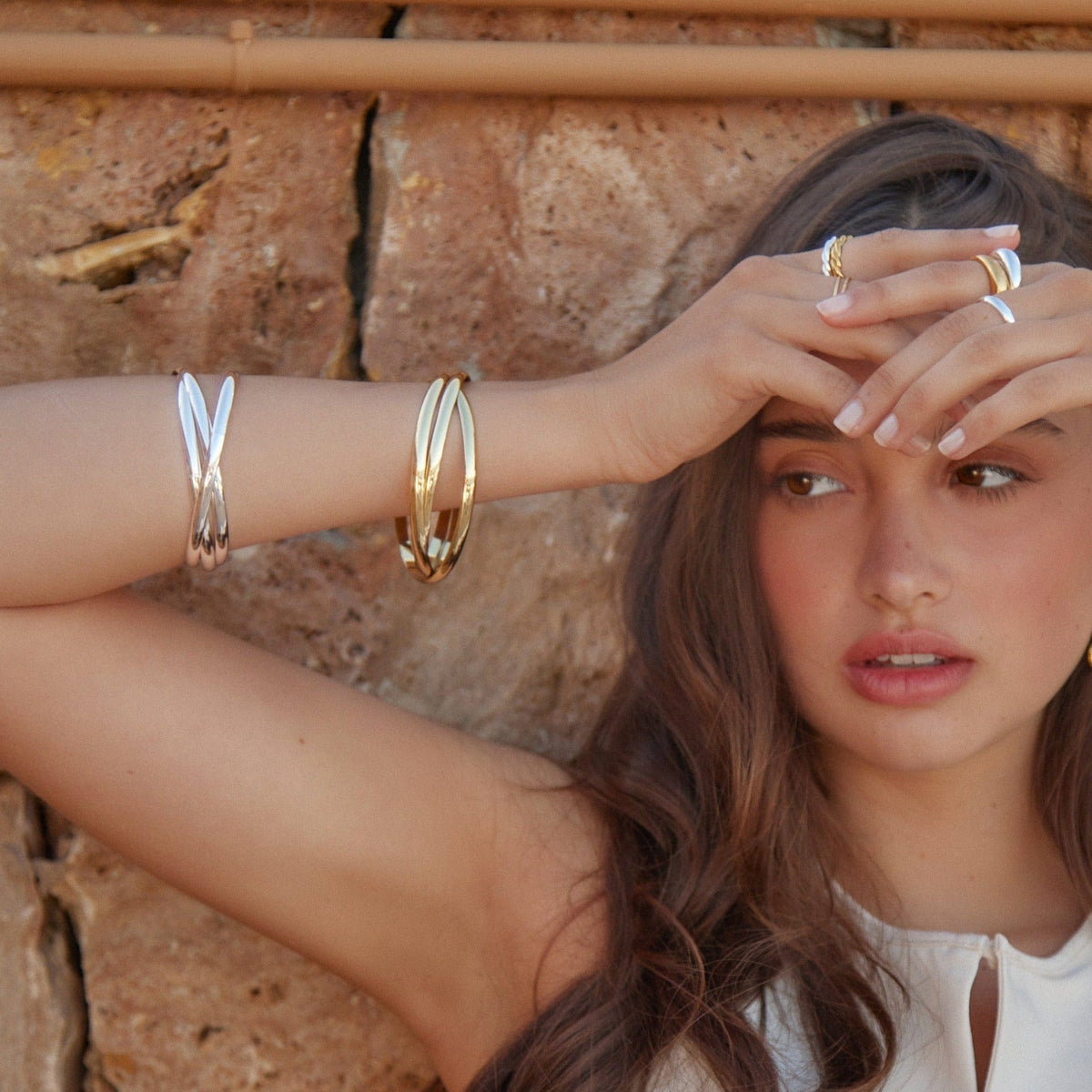 Interlocking bangles worn with silver bangles on a raised arm