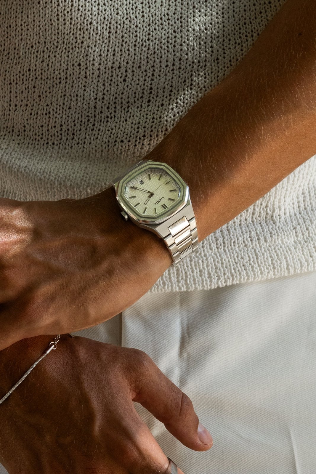 Watch on a wrist against a knit sweater