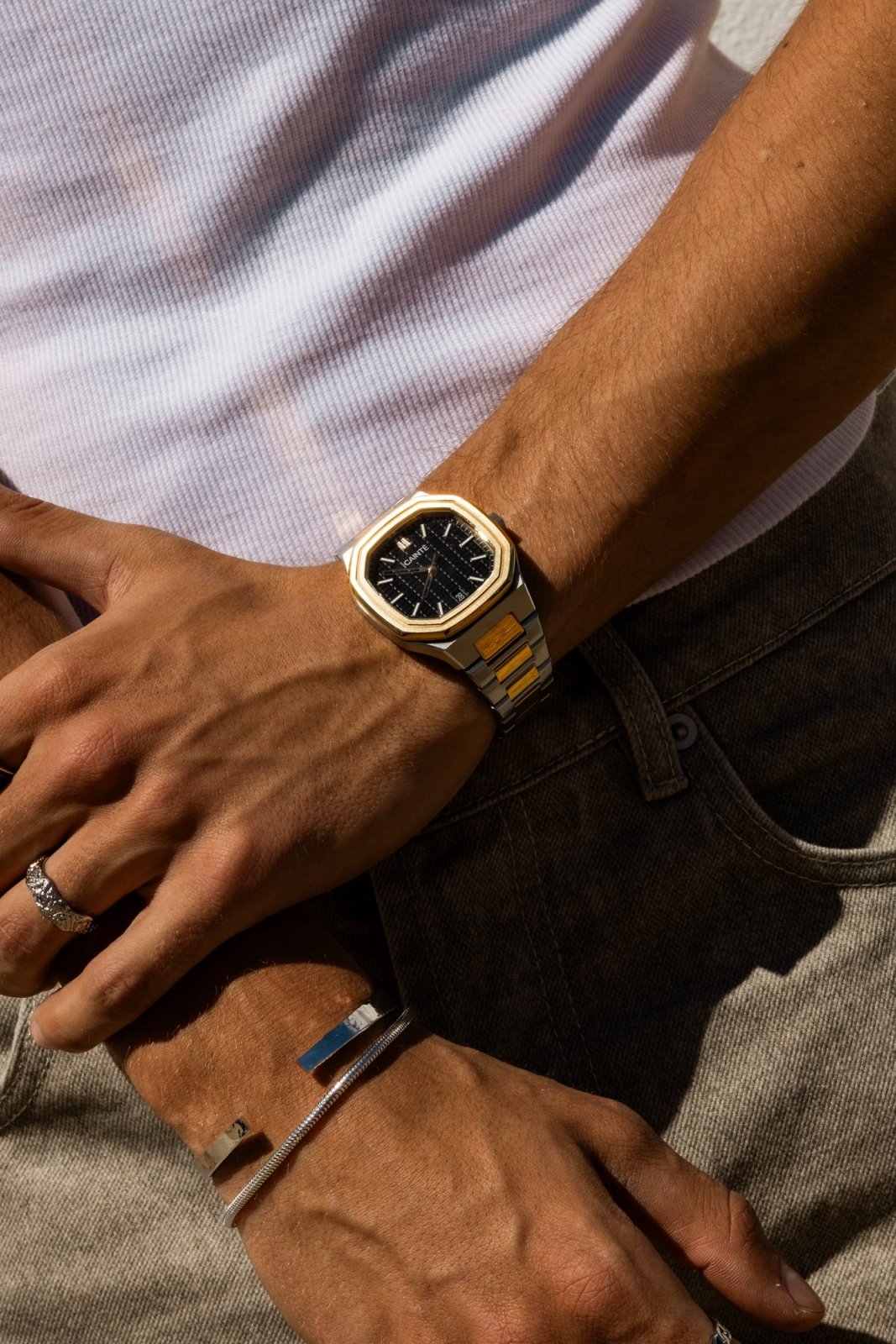 Close view of hands over jeans with the watch