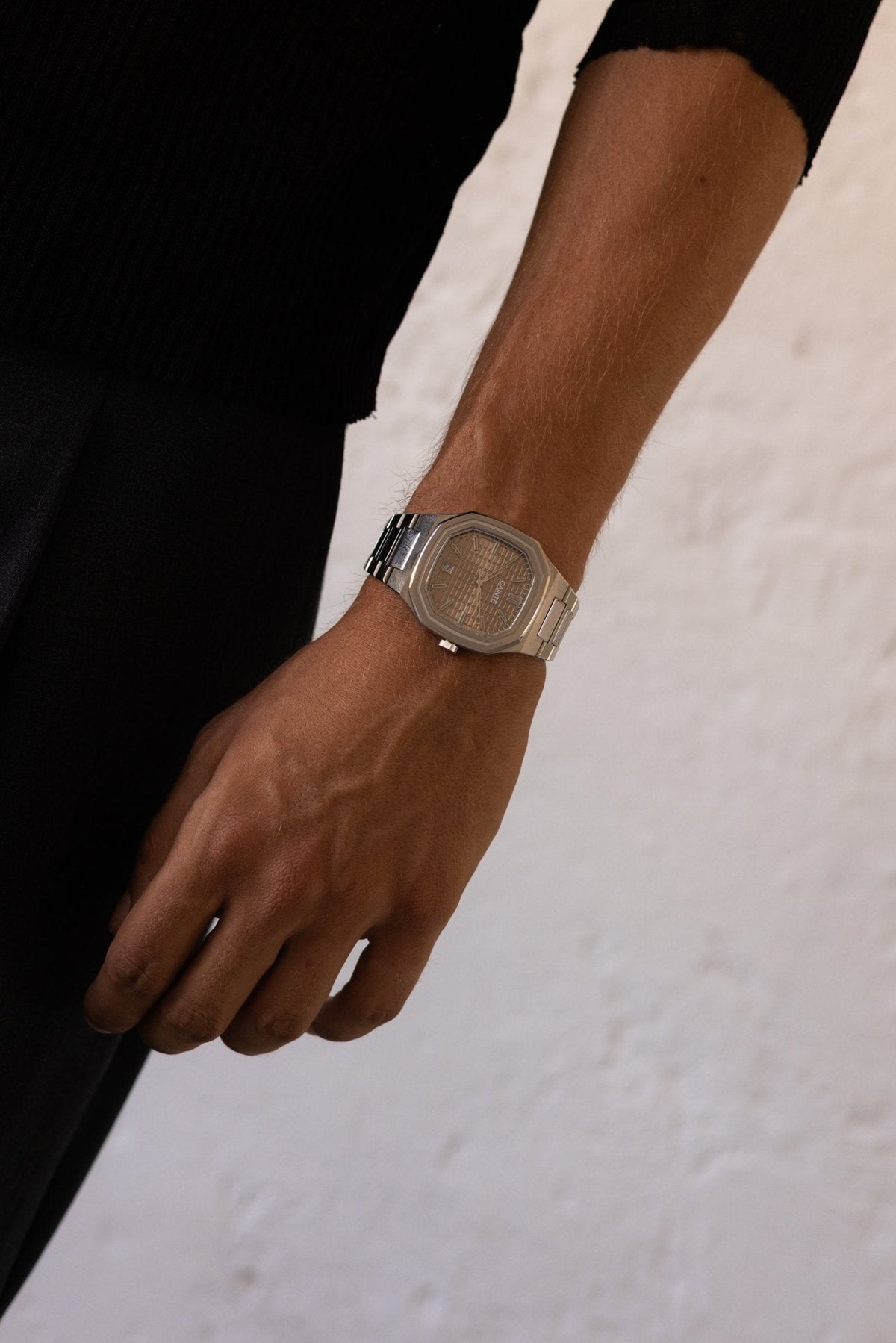 Arm hanging by the side wearing the watch