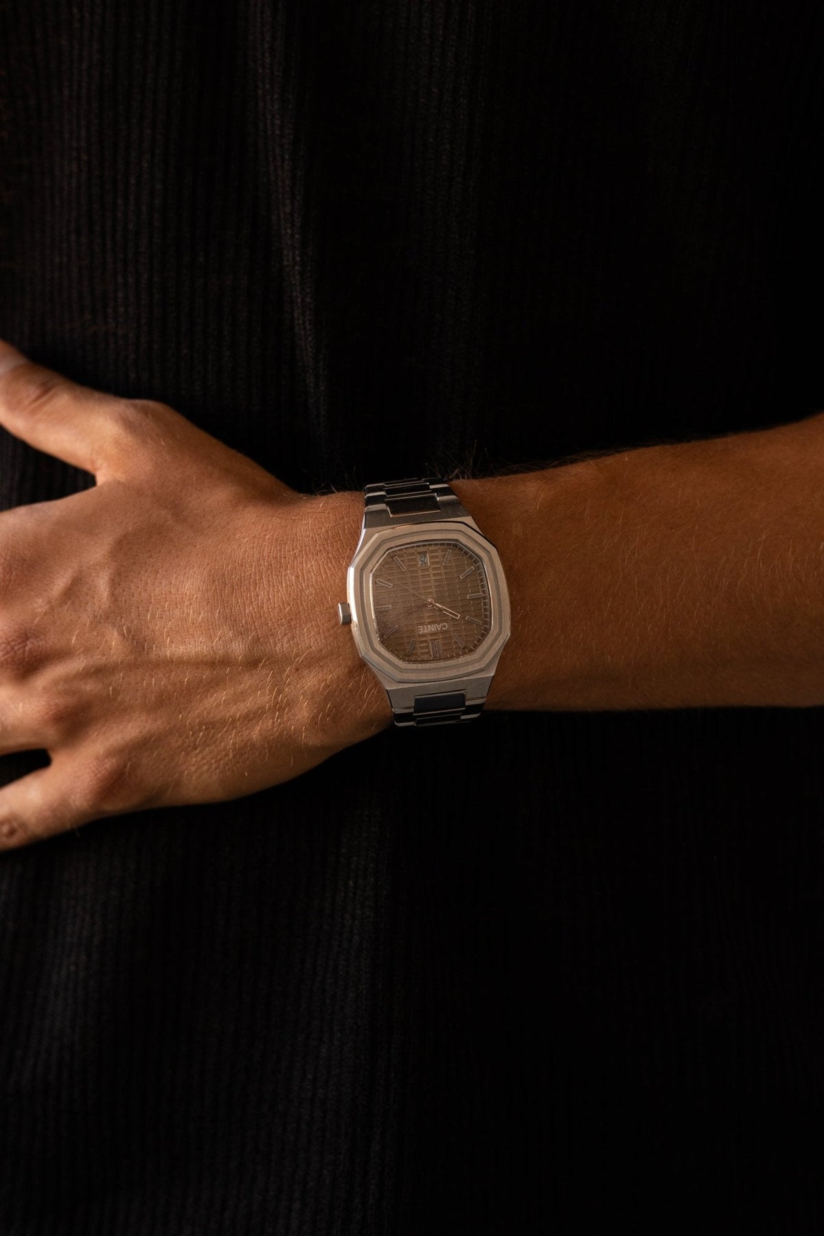 Hand over a black shirt with the watch on the wrist