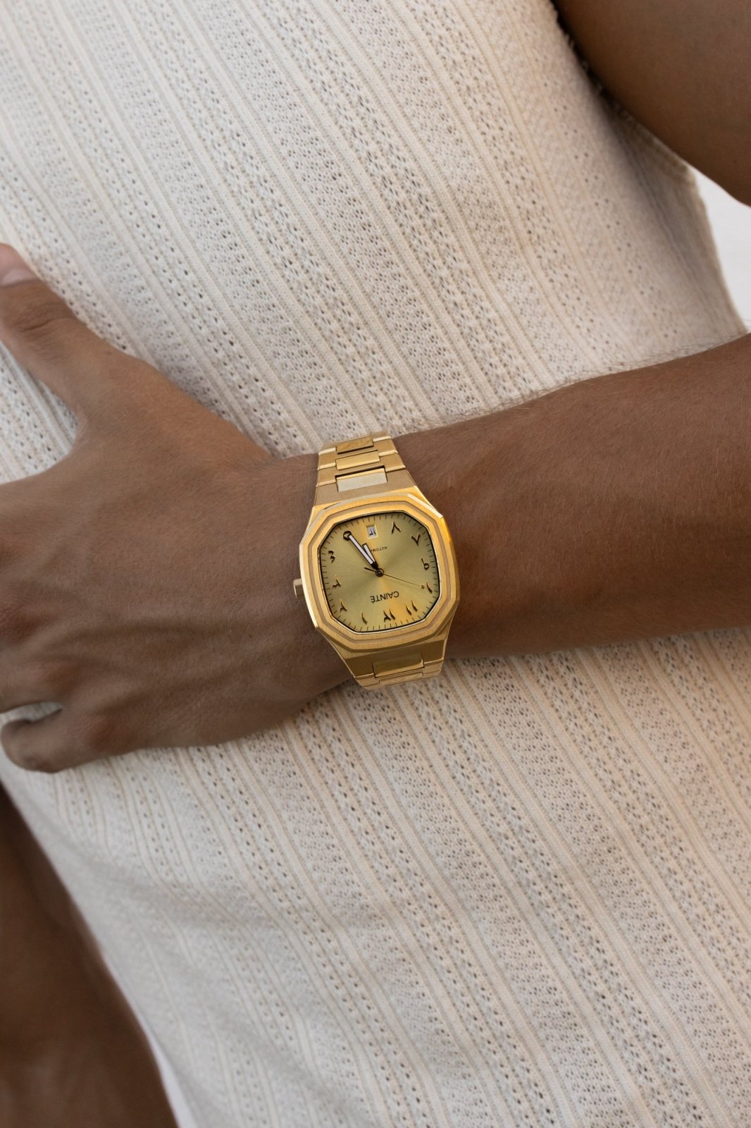 Watch on a wrist against a ribbed knit top
