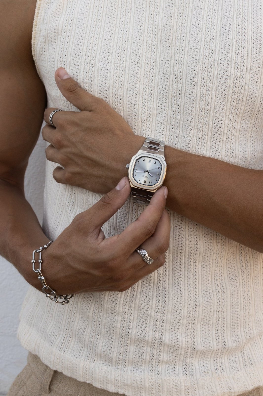 Hand adjusting the watch over a ribbed knit tank