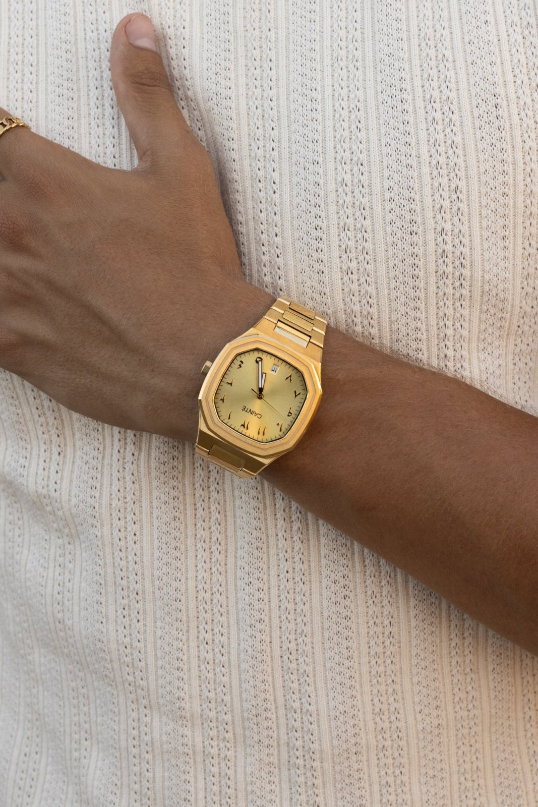 Watch on a wrist against a ribbed knit top
