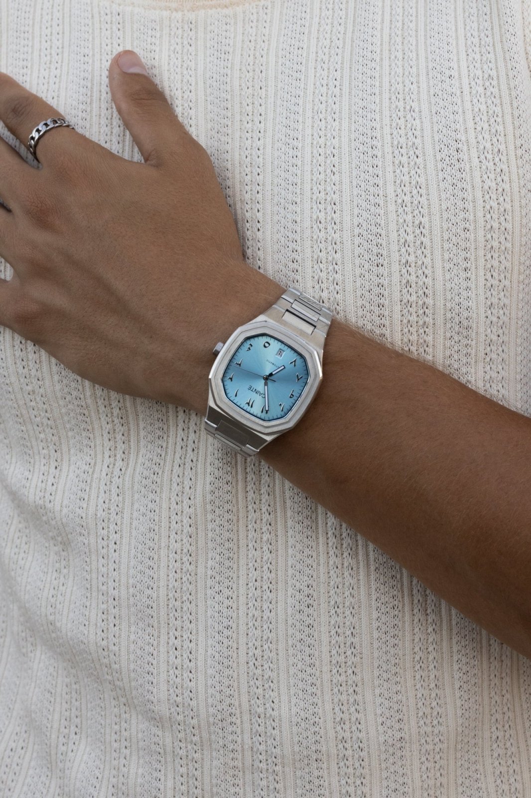 Watch on a wrist against a ribbed knit top