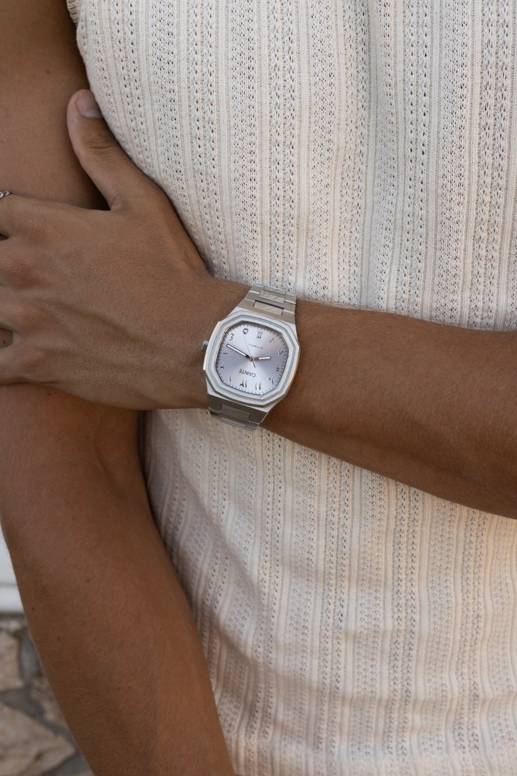 Arm across the body wearing the watch over a knit tank