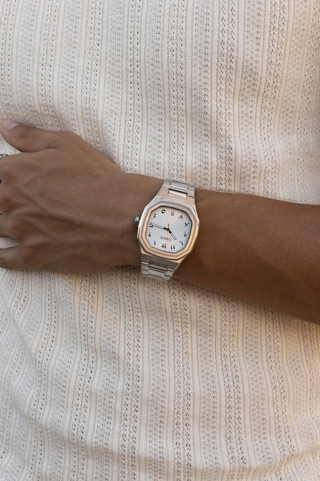 Watch on a wrist against a ribbed knit top