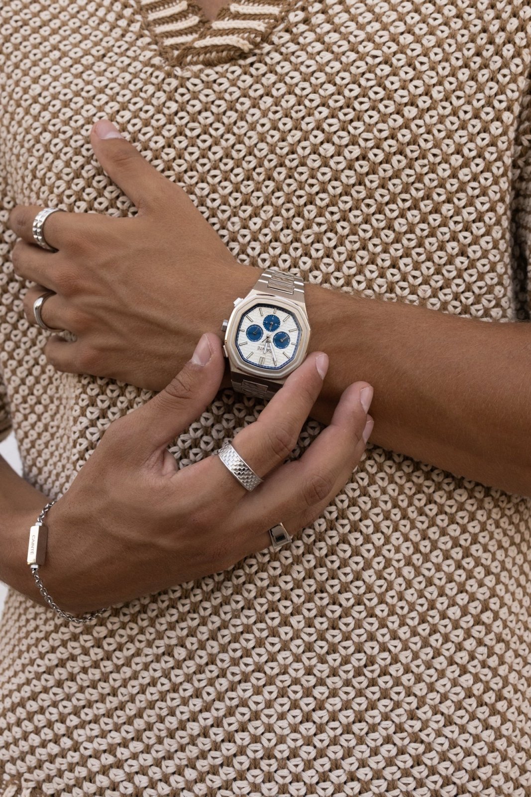 Hand on a tan knit top wearing the watch
