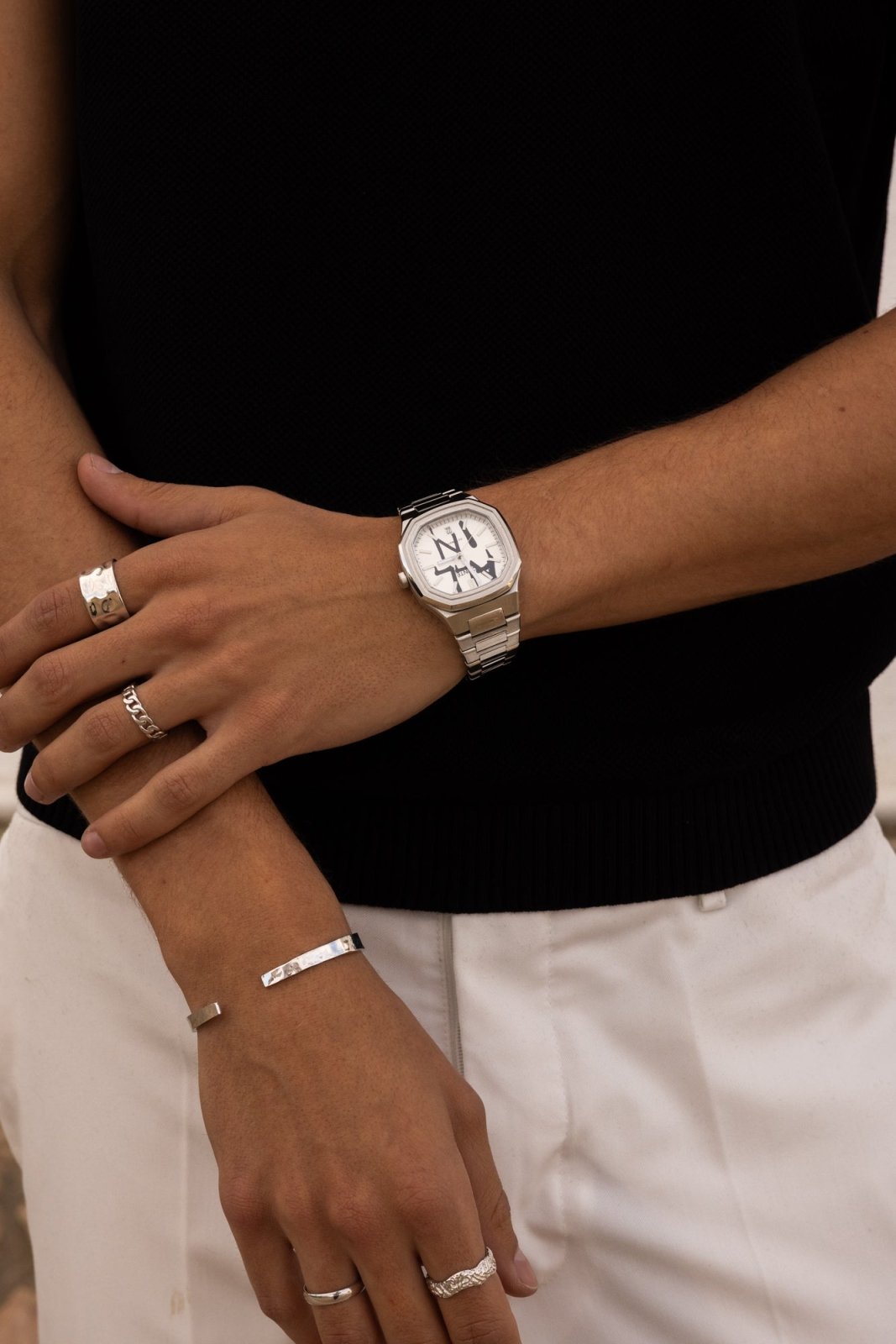 Arms crossed over a black top with the watch